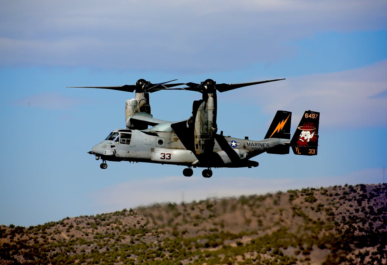 brand-03 A modern military aircraft flying over the Nevada desert under a blue sky.