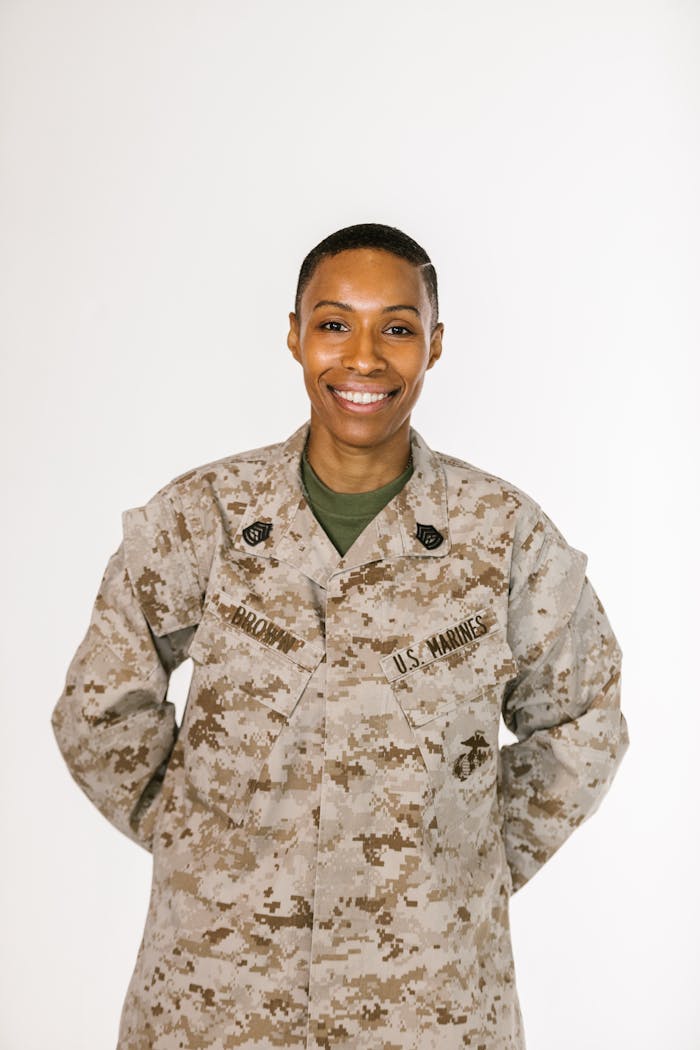 creative-01 Confident female US Marine in uniform smiling against a white background.