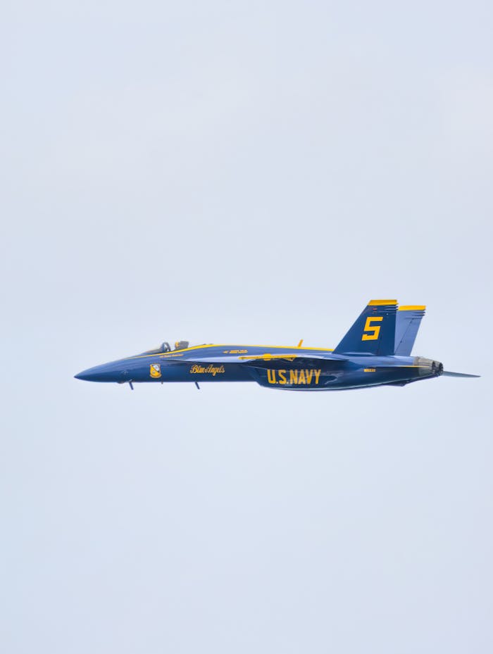 creative-02 A US Navy Blue Angels jet performs in an aerial display, showcasing precision flying.